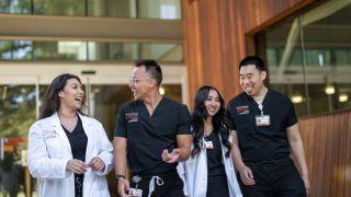 图为正规博彩十大网站健康科学学院的四名护理专业学生微笑着交谈着走出护理教室.